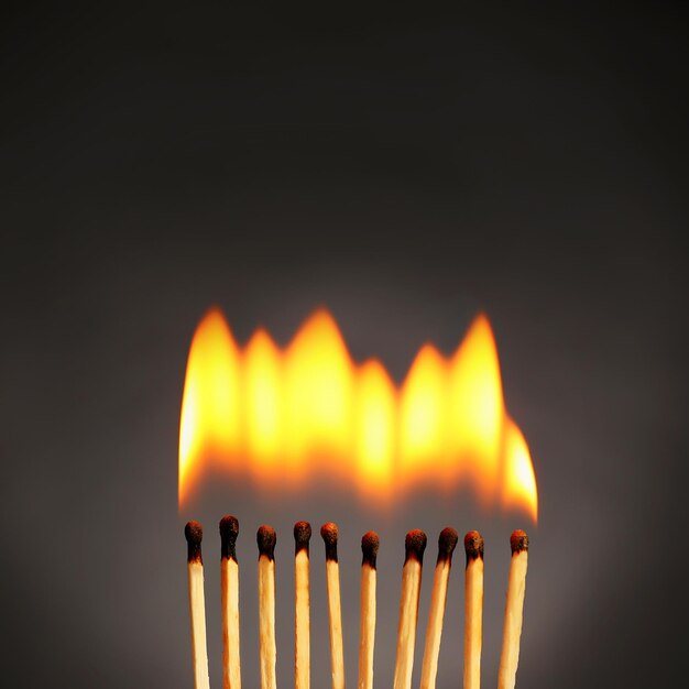 Burning matches on dark gray background