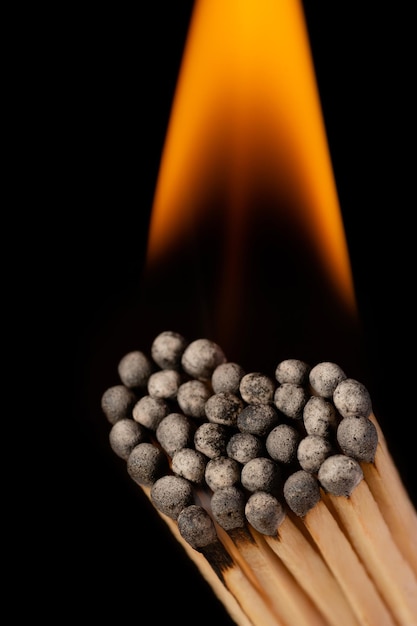 Burning matchsticks in shape of heart against black background. Concept of love