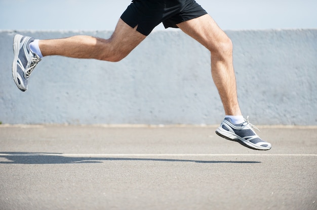 Burning the miles away.  Side view close-up image of man running outdoors