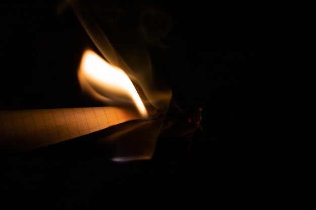 Burning paper in the dark close up