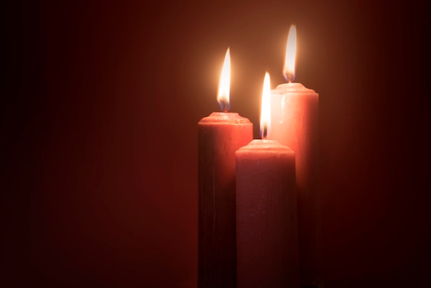 Burning red candle with dark background