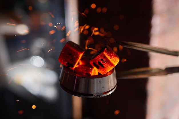 Burning red coals for hookah during preparation