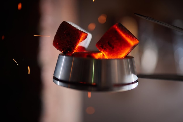 Burning red coals for hookah during preparation