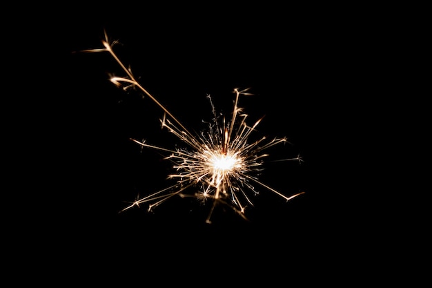 Burning sparkler isolated on black background Fireworks theme Light effect and texture