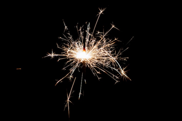 Burning sparkler isolated on black background Fireworks theme Light effect and texture