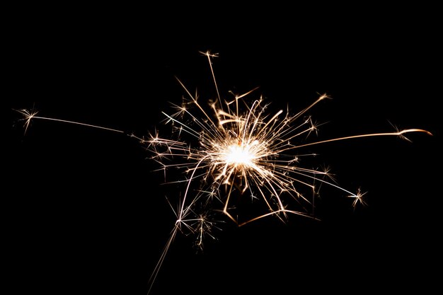 Burning sparkler isolated on black background Fireworks theme Light effect and texture