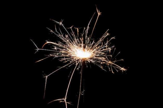 Burning sparkler isolated on black background Fireworks theme Light effect and texture