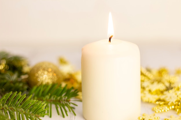 Burning white candle and Christmas tree