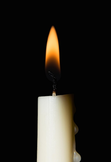 Foto candela bianca accesa. isolato su sfondo nero