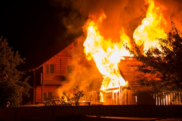 Burning wooden house at night