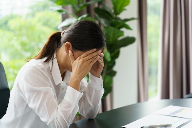 Burnout concept asian business woman touching forehead having headache boring job and tired emotional pain and professional person depressed over risk