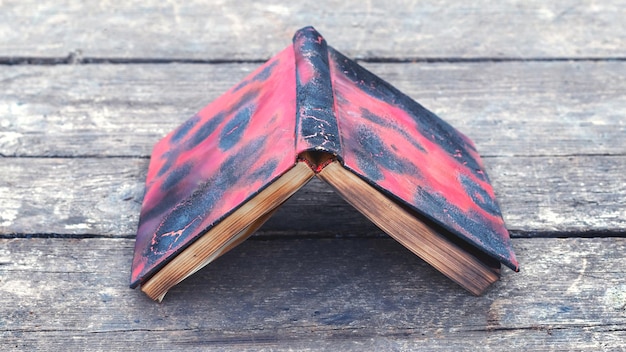 A burnt book on a wooden table with the cover up Barbaric treatment of books