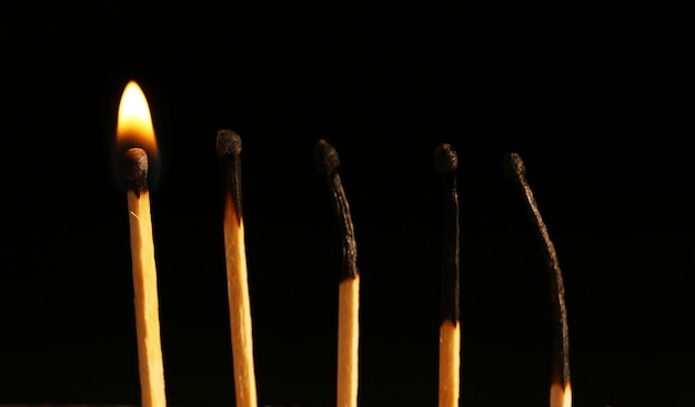 Photo burnt and burning matches on black background