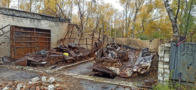 Burnt cars in destroyed garages during war in Ukraine Destroyed cars Burnt transport after shelling of Russian army of city in Ukraine RussianUkrainian War Destroyed buildings and cars during war