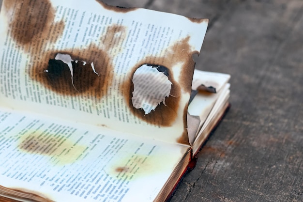 Burnt charred book on a wooden table