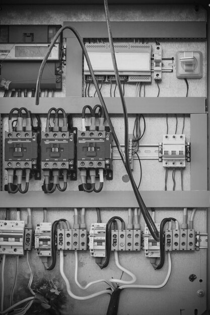 Burnt out wiring in switchboard with toggle switches in black and white photo