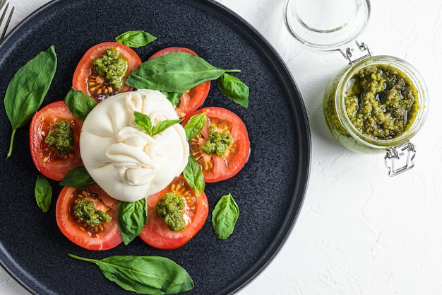 Burrata Buffalo-kaas geserveerd met verse tomaten en pestosaus