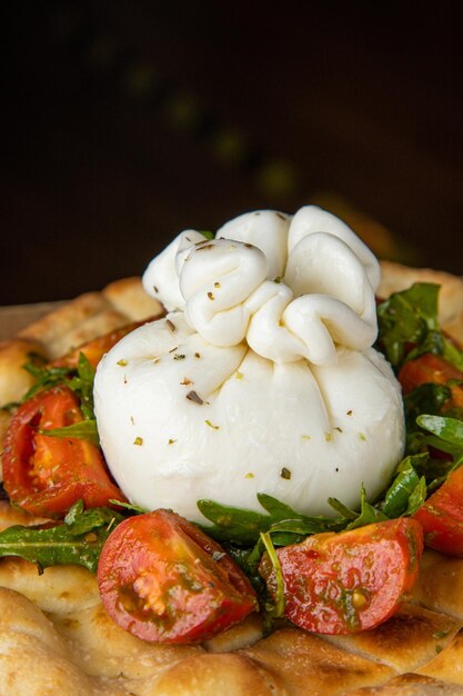 Burrata Caprese Salad with Spinach with Burrata Caprese cherry tomatoes and Black background