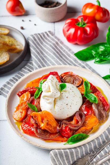 Burrata con pomodorini al forno, peperoni e cipolla rossa fresca