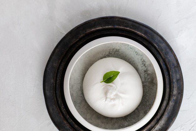 Burrata cheese with basil leave top view, white , copyspace