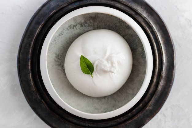 Burrata cheese with basil leave top view, white , copyspace