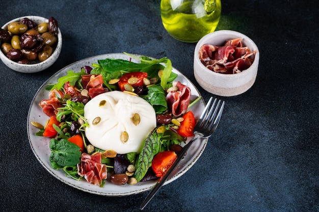 Burrata italiaanse verse kaas gemaakt van room en melk van buffel of koe burrata salade met tomaten en salade mix gezond eetconcept keto dieet salade