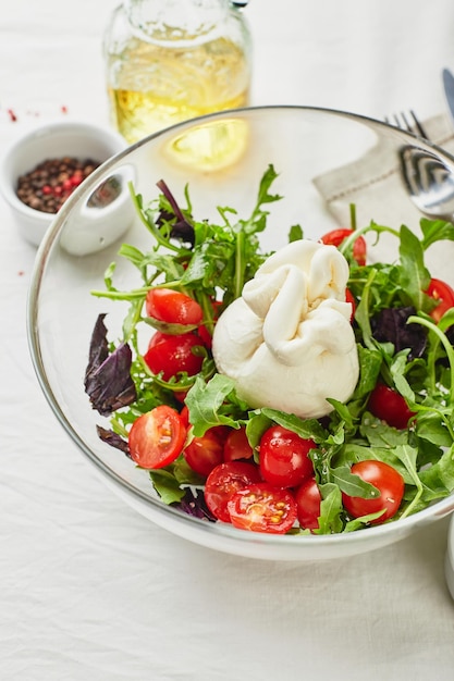 Burrata formaggio fresco italiano a base di panna e latte di bufala o di vacca con pomodoro rucola e insalata di basilico rosso