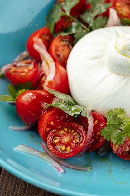 Burrata kaassalade met aardappelen in een blauw bord