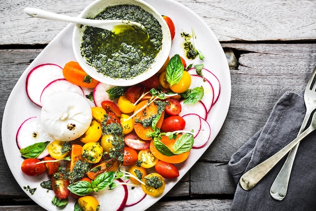 Photo burrata with colorful cherry tomatoes salad with homemade pesto