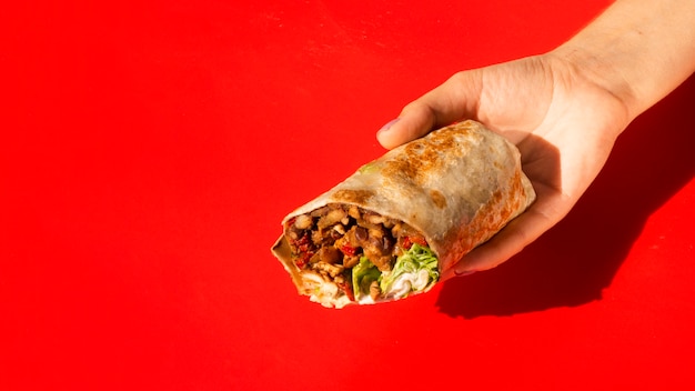 Burrito van de de vrouwenholding van de close-up met exemplaar-ruimte