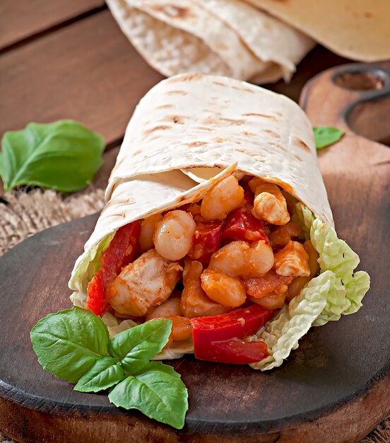 Burrito con pollo, fagioli, pomodori e peperoni