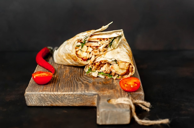 Burrito wraps met kip en groenten op een snijplank, tegen een achtergrond van beton, Mexicaanse shoarma