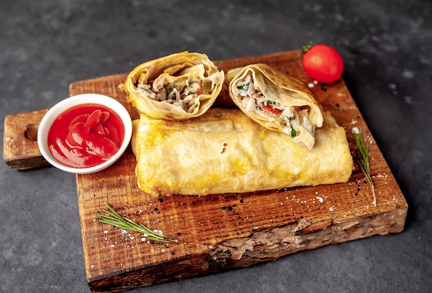 Burrito wraps with chicken and vegetables , against a background of concrete, Mexican shawarma