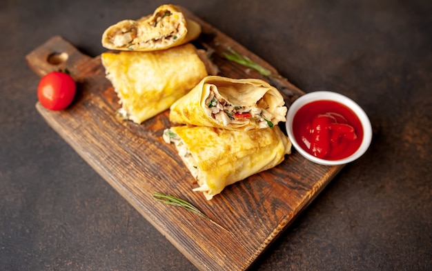 Burrito wraps with chicken and vegetables , against a background of concrete, Mexican shawarma