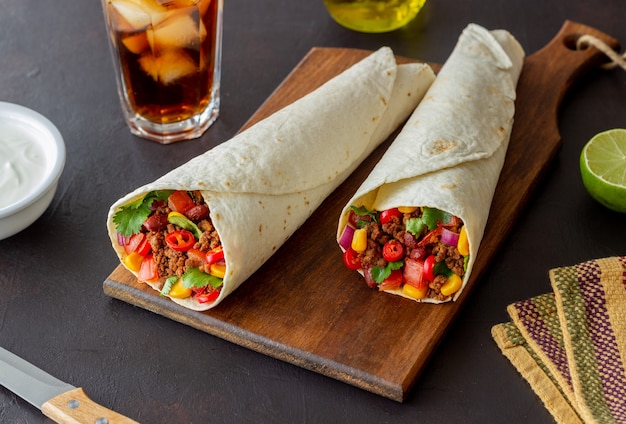 Burritos with meat, beans, corn, tomatoes, onions and chilli. Mexican food. Recipe.