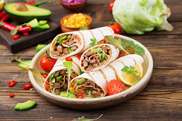 Burritos wraps with beef and vegetables on a wooden table. Beef burrito , mexican food. Mexican cuisine.