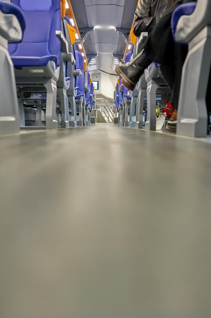 A bus with blue seats and a person sitting on the back of it.