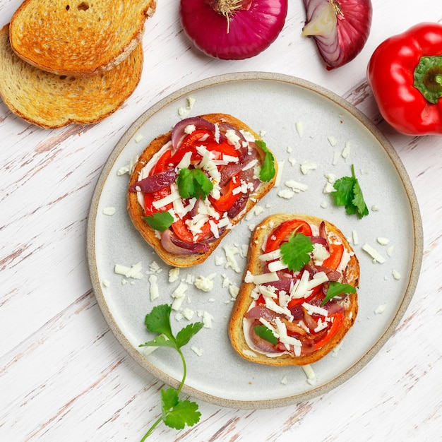 Foto buscetta met geroosterde rode paprika, ui, fetakaas, koriander en kruiden