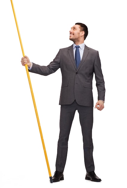 business and advertisement concept - smiling businessman holding flagpole with imaginary flag