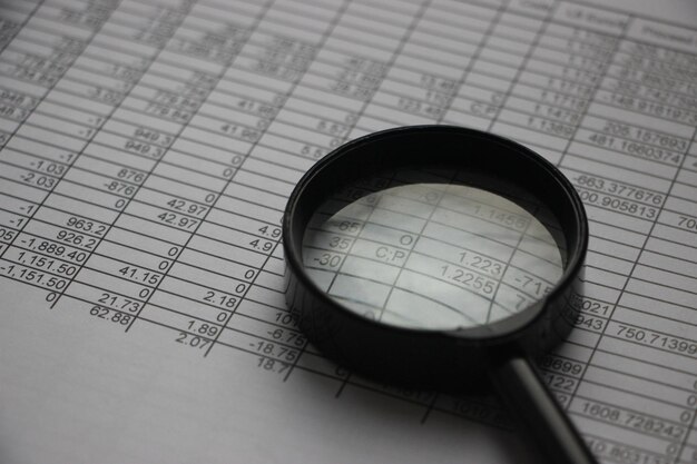 Photo business analyst using magnifyer to review financial report financial concept