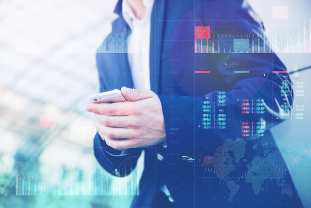 Business analytics with key performance indicators dashboard concept. Businessman in a blue jacket holds a smartphone in his hands.