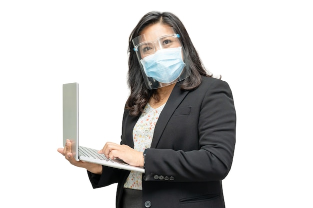 Business asian lady wearing face shield and face mask holding laptop.