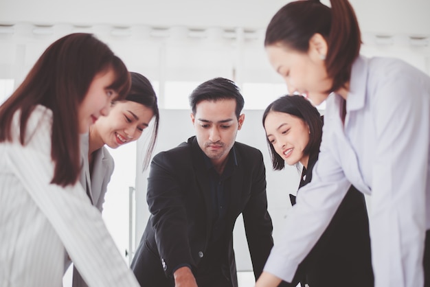 Lavoro di discussione del team asiatico aziendale in ufficio, persone che condividono idee e discutono di progetti, concetto di riunione di brainstorming