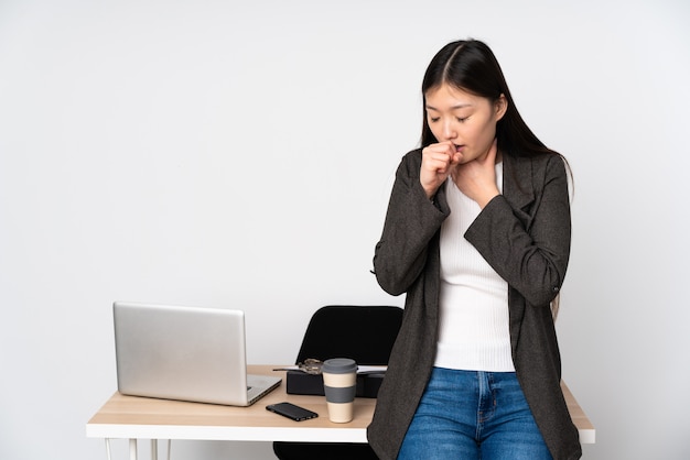 Бизнес азиатская женщина на своем рабочем месте на белой стене страдает от кашля и плохо себя чувствует