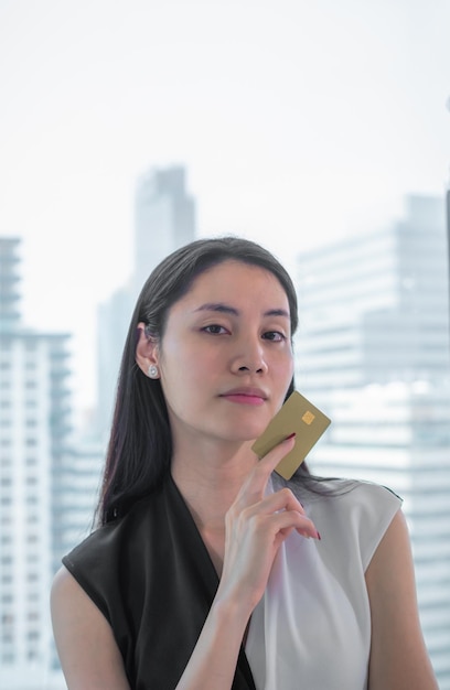 Donna asiatica di affari che tiene carta di credito