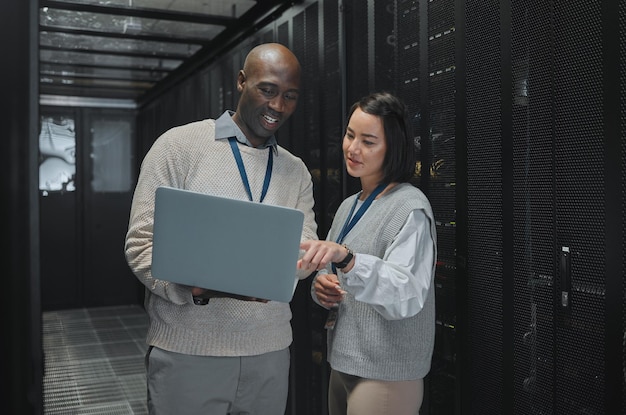 Business black man and woman with laptop servers and cyber security for connection data analytics and conversation IT specialist female programmer and employees with device and cloud computing