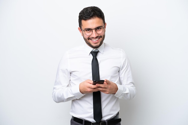 Business Brazilian man isolated on white background sending a message with the mobile