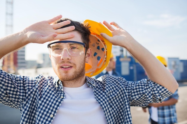 business, building, teamwork and people concept - group of builders in hardhats outdoors