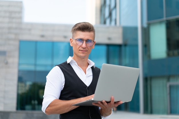 Business. Businessman Using Laptop Outdoors. Serious Pensive Caucasian Male Eyeglasses Business Person Computer Outside Modern Technology Concept Young Adult Manager Crisis Thinking Trouble Idea