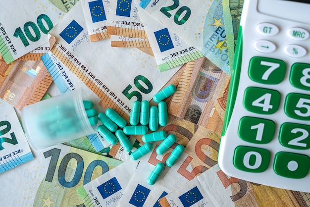 Business calculator pharmacy pills and euro banknotes. medical\
concept